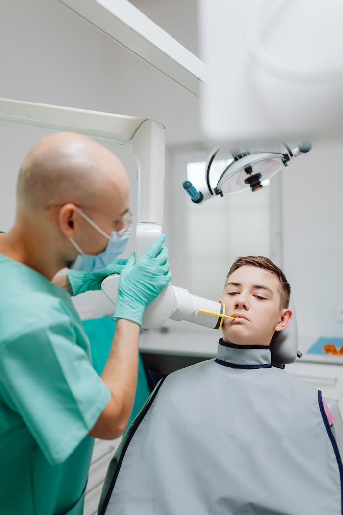 Teen boy receiving dental X-ray in a modern clinic