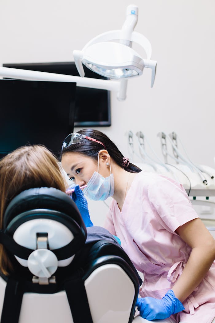 services-04 A dentist in a mask examines a patient in a modern, well-equipped dental clinic.