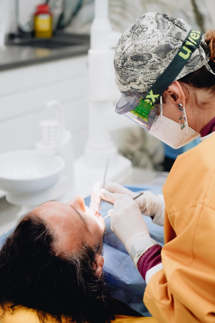 about-01 A dentist performs a dental procedure on a patient in a modern clinic setting.